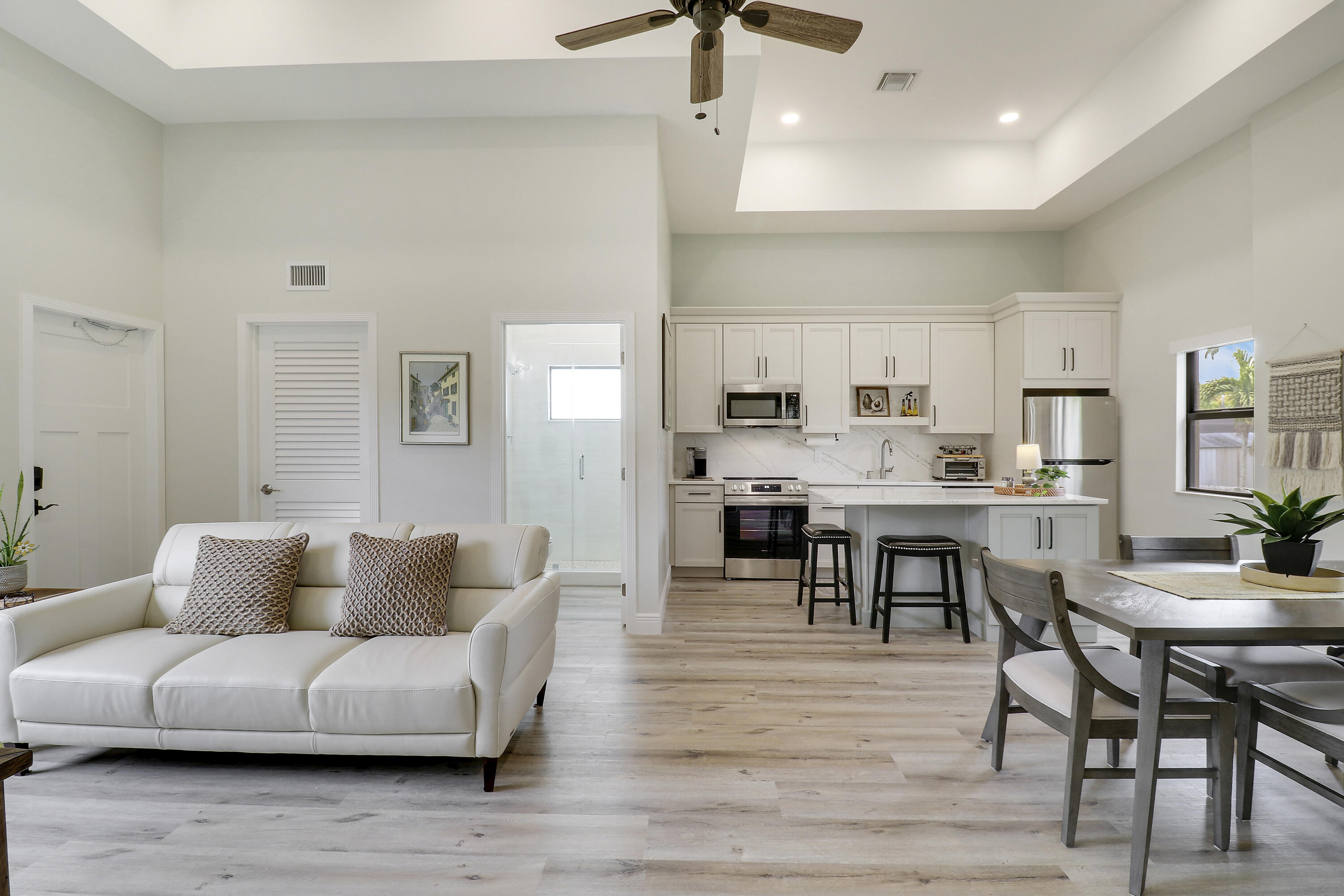 a living room kitchen with furniture and wooden floor