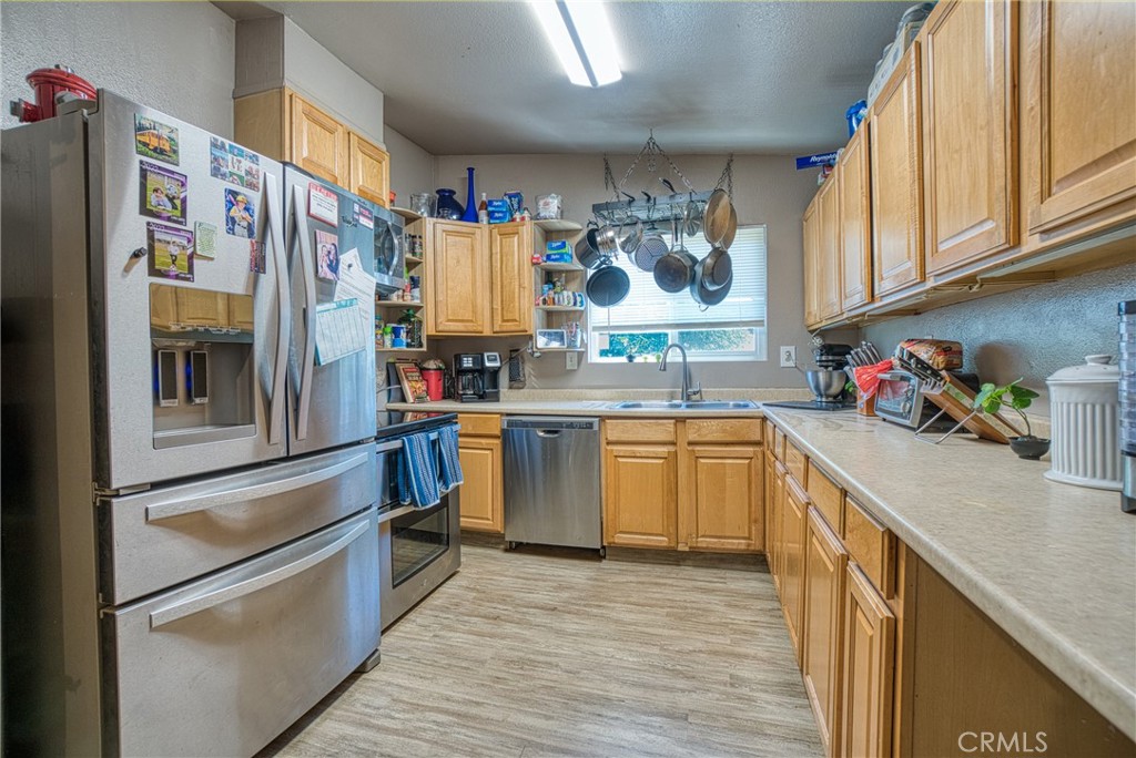 14415 Ridge Road Clearlake, CA 95422 - Photo 17 of 28 a kitchen with stainless steel appliances granite countertop a refrigerator and a sink