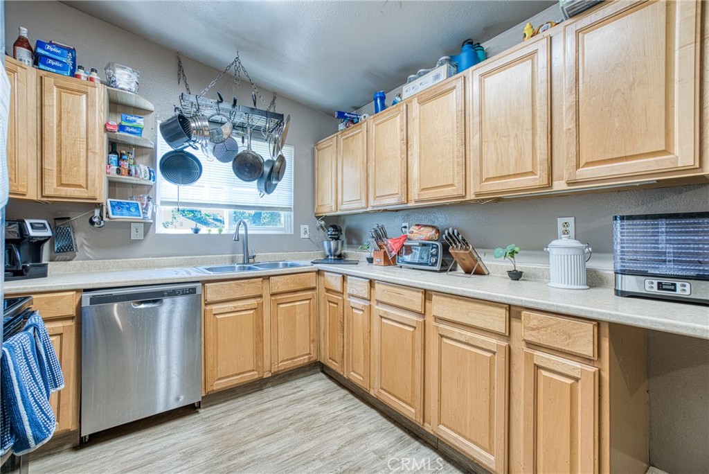 14415 Ridge Road Clearlake, CA 95422 - Photo 19 of 28 a kitchen with stainless steel appliances granite countertop a sink and cabinets with wooden floor
