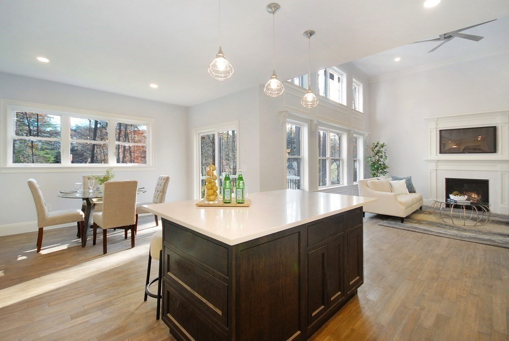 73 Seminole Road Acton, MA 01720 - Photo 14 of 33 a living room with furniture a fireplace and a dining table with wooden floor