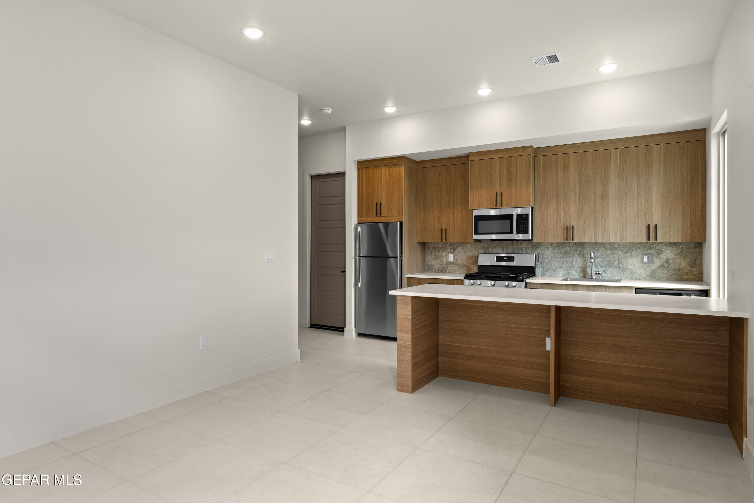 7436 Cimarron Rim Drive El Paso, TX 79911 - Photo 14 of 18 a large kitchen with stainless steel appliances a sink and cabinets