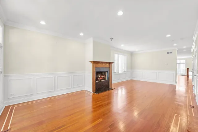 a view of empty room with wooden floor and fireplace