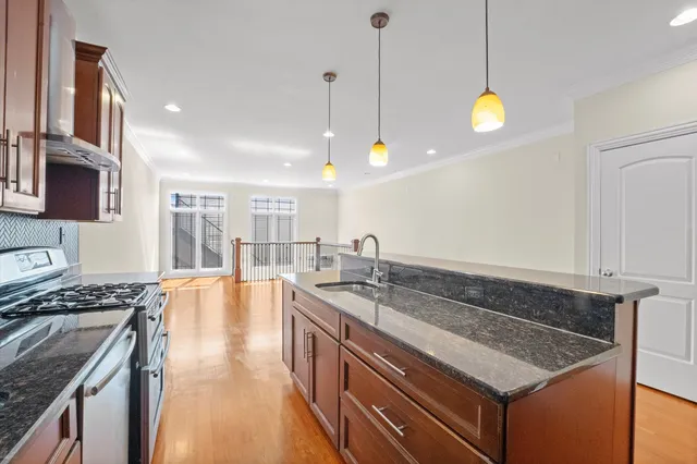 a kitchen that has a stove a sink a counter space and cabinets