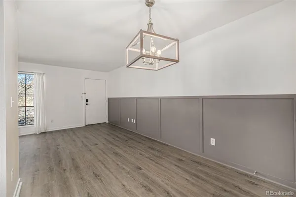 an empty room with wooden floor and white walls