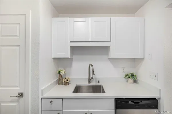 a kitchen with white cabinets and a sink
