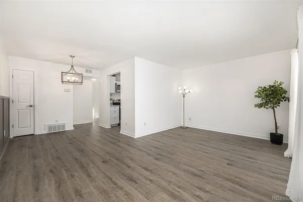 a view of empty room with wooden floor and entryway