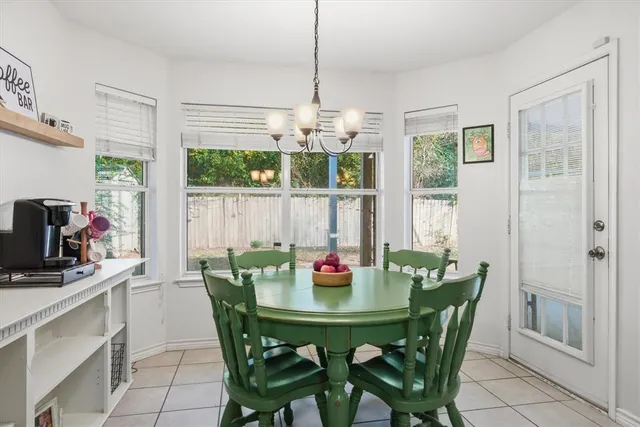 a dining room with furniture a chandelier and window