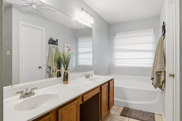 a bathroom with a tub sink and mirror