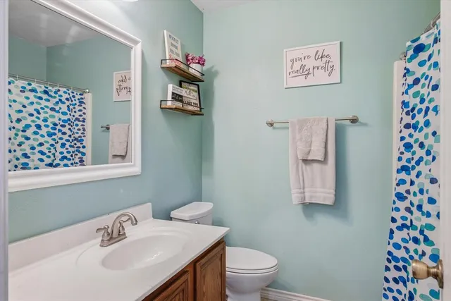 a bathroom with a sink mirror vanity and toilet