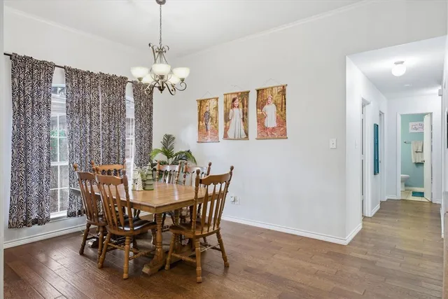 a view of a dining room with furniture wooden floor and chandelier