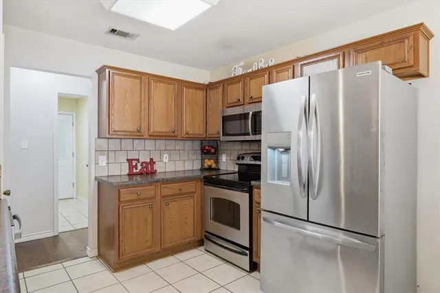 a kitchen with a refrigerator a sink and cabinets