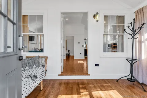 a view of a hallway with wooden floor and a living room