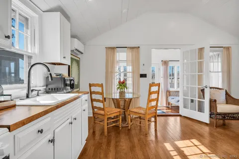 a kitchen with stainless steel appliances a dining table chairs and granite counter tops