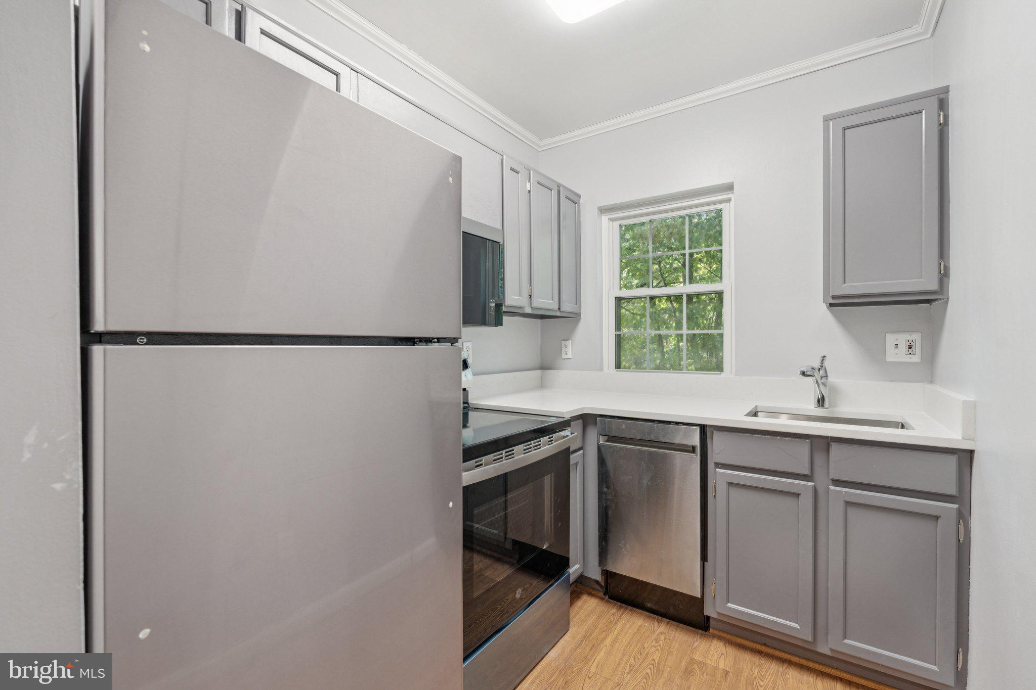 1909 North Rhodes Street, Unit 30 Arlington, VA 22201 - Photo 5 of 14 a kitchen with a sink cabinets and window