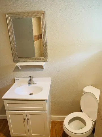 a bathroom with a sink mirror vanity and toilet