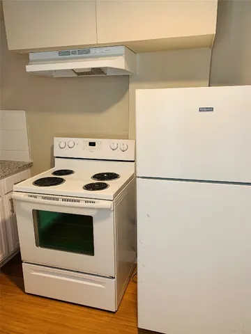 a close view of washer and dryer with wooden floor