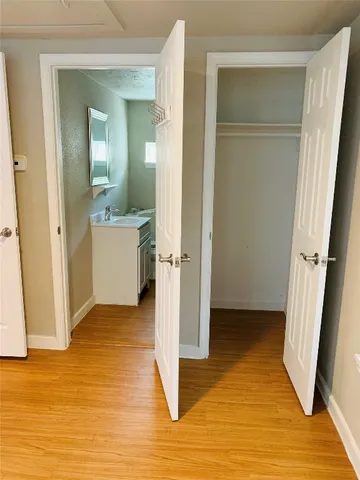 a view of a room with wooden floor and a bathroom