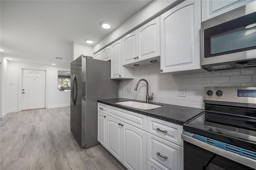 3409 Corey Road Sarasota, FL 34232 - Photo 11 of 19 a kitchen with stainless steel appliances granite countertop a refrigerator and a stove top oven