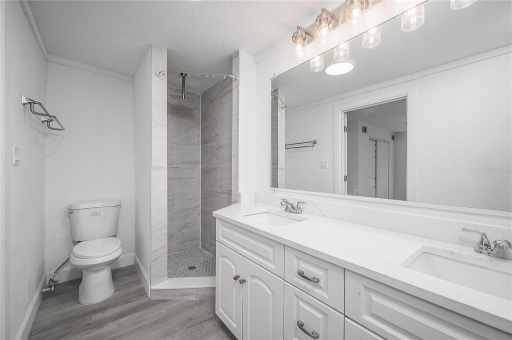 3409 Corey Road Sarasota, FL 34232 - Photo 9 of 19 a bathroom with a double vanity sink a toilet and a mirror