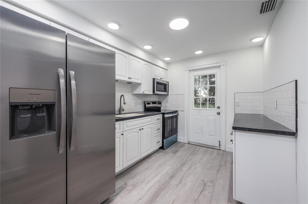 3409 Corey Road Sarasota, FL 34232 - Photo 10 of 19 a kitchen with granite countertop a refrigerator and a sink