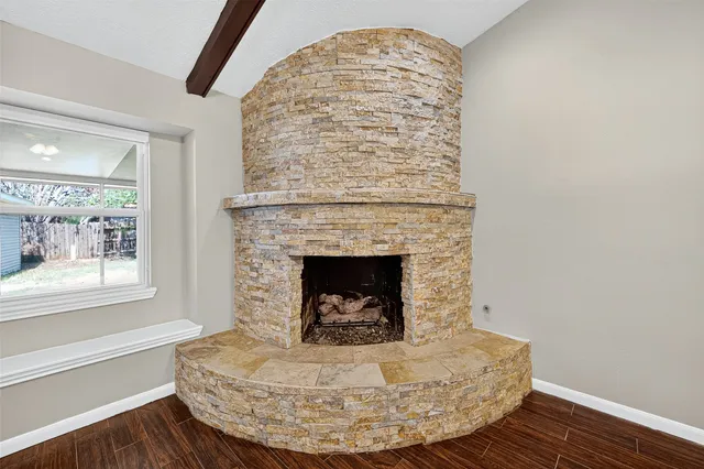a living room with a fireplace and wooden floor