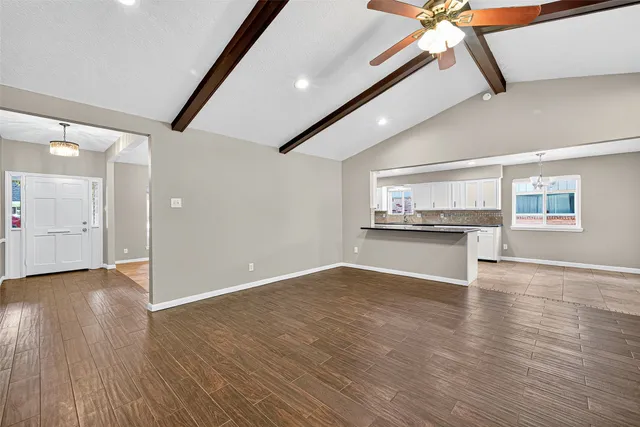 a view of an empty room with wooden floor