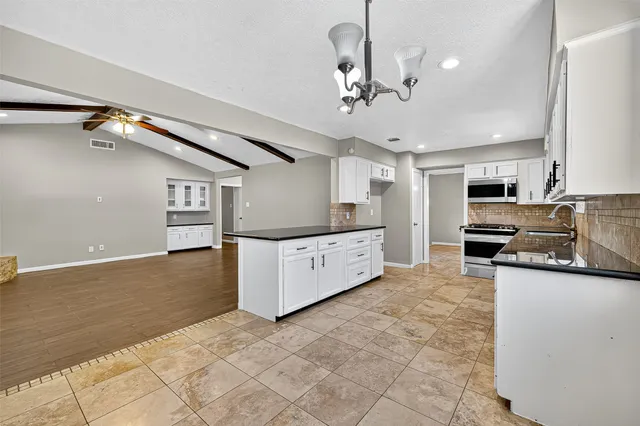 a large kitchen with cabinets and stainless steel appliances