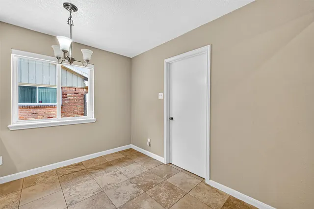 a view of an empty room with window and cabinet