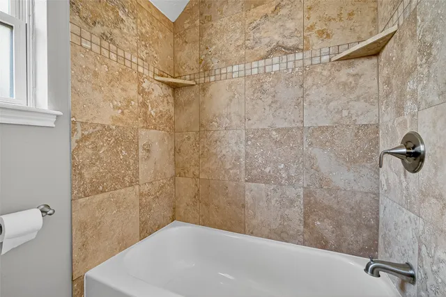 a bathroom with a white bath tub and a shower