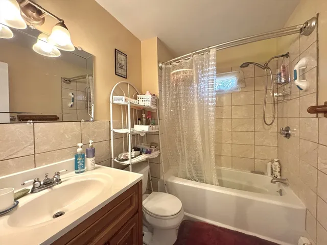 a bathroom with a sink toilet a mirror and shower