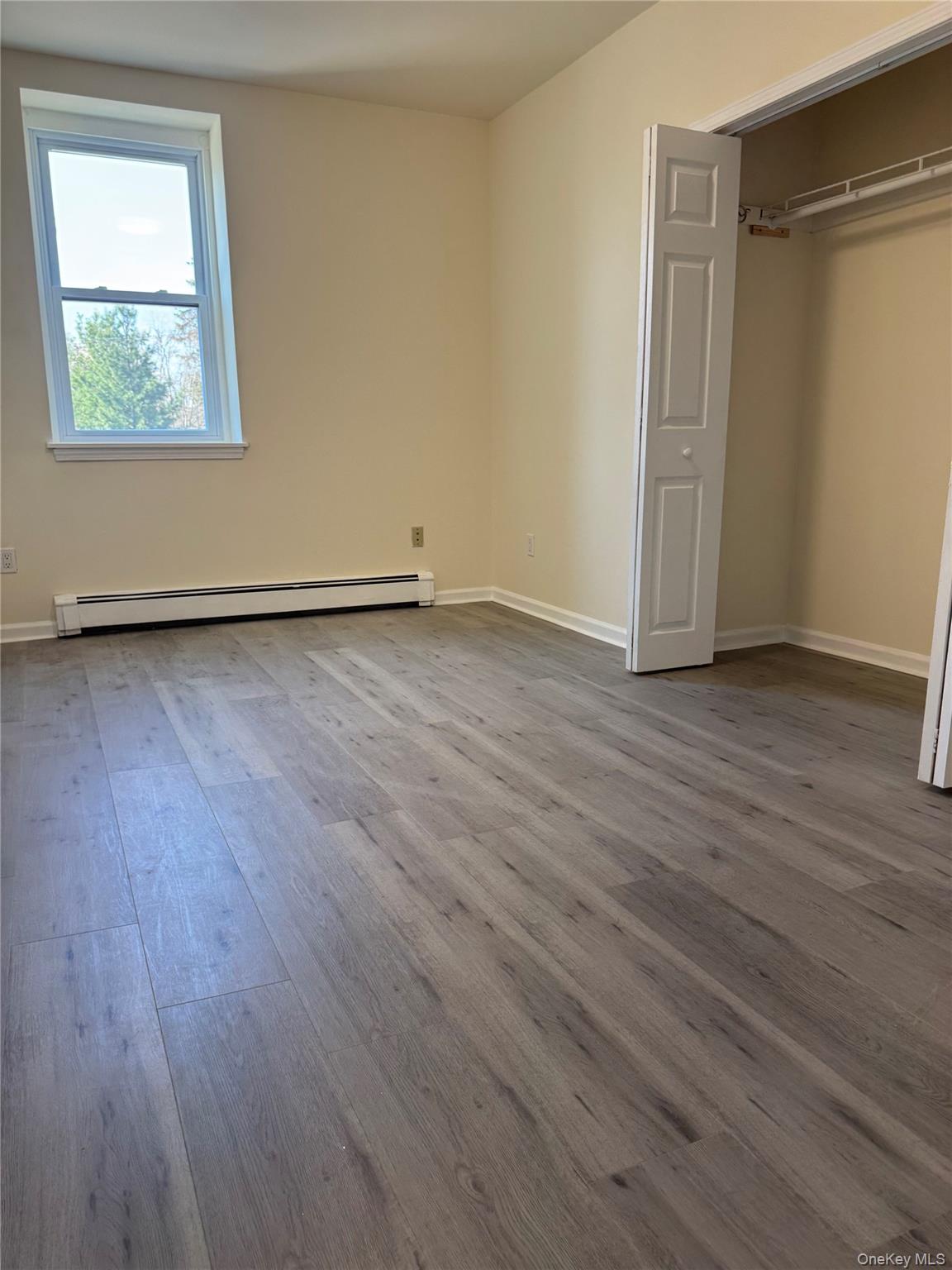 167 Main Street, Unit 2 Beacon, NY 12508 - Photo 13 of 19 an empty room with wooden floor and windows