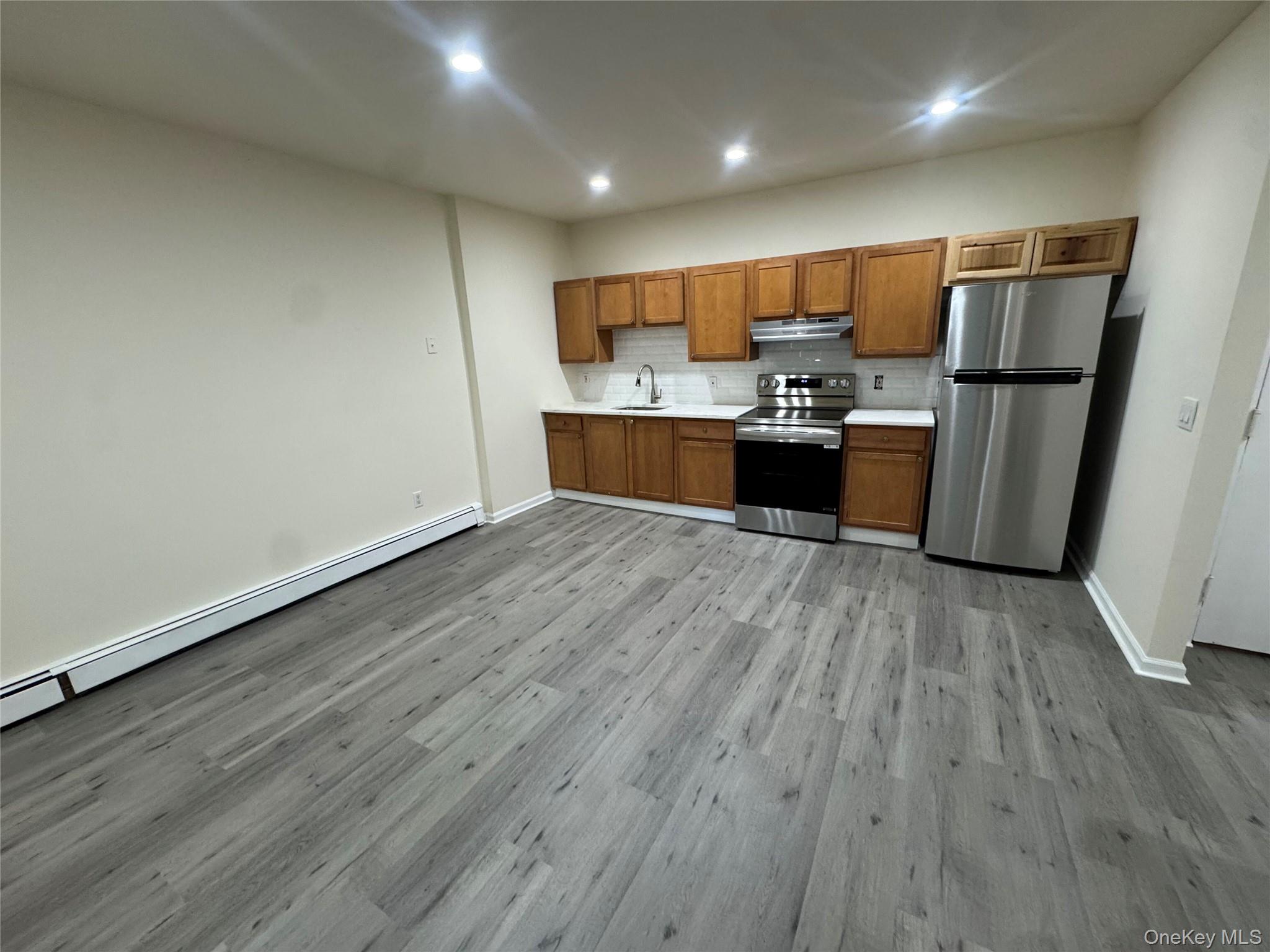 167 Main Street, Unit 2 Beacon, NY 12508 - Photo 5 of 19 a kitchen with stainless steel appliances wooden floors and wooden cabinets