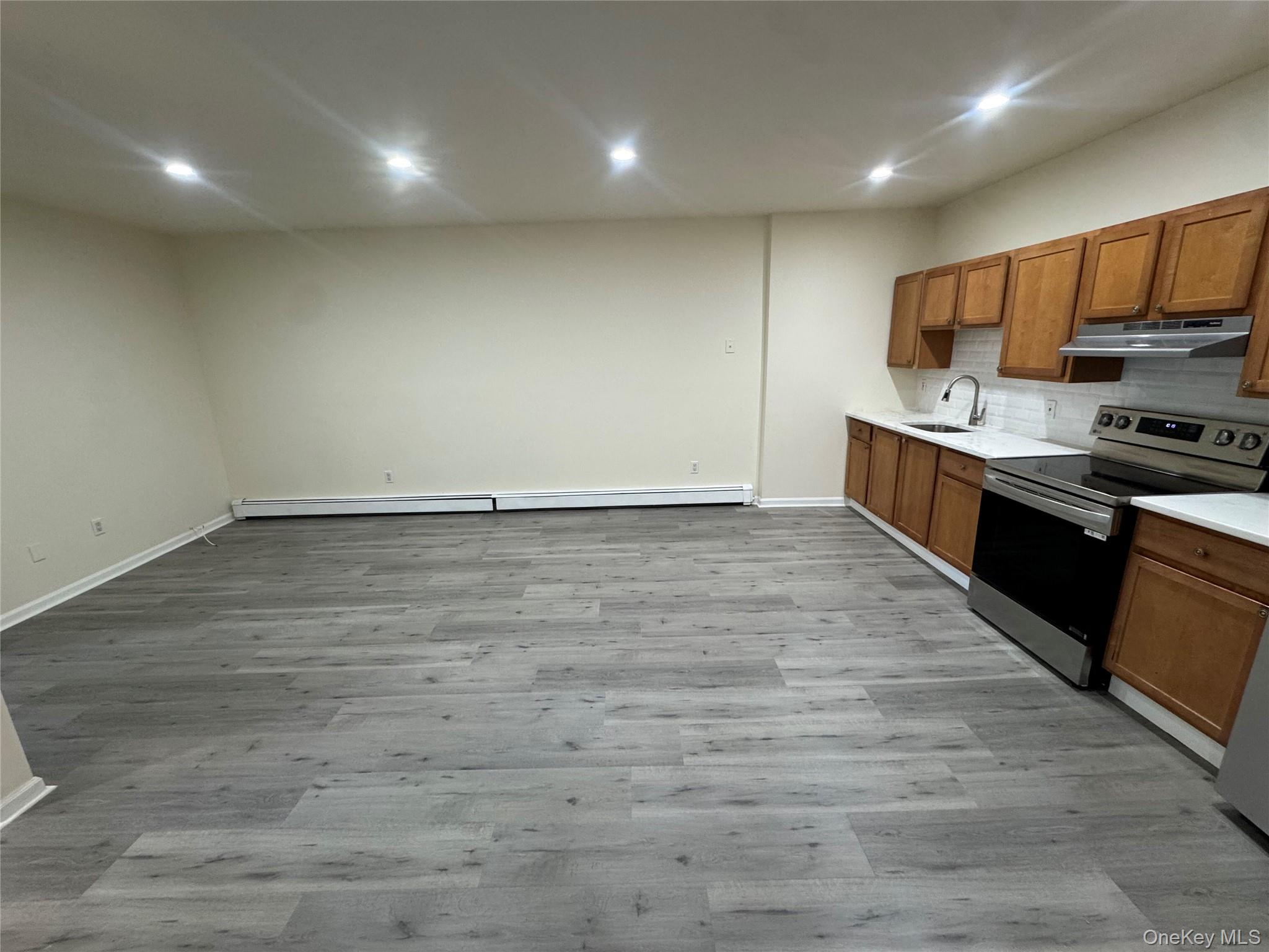 167 Main Street, Unit 2 Beacon, NY 12508 - Photo 6 of 19 a large kitchen with stainless steel appliances granite countertop a stove a sink and a refrigerator