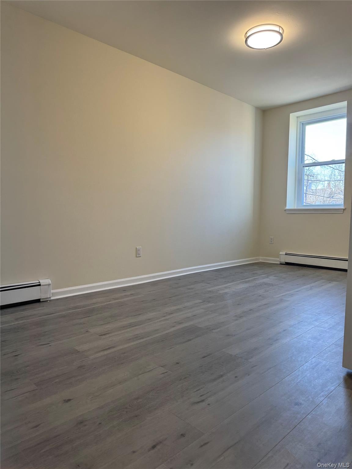 167 Main Street, Unit 2 Beacon, NY 12508 - Photo 10 of 19 a view of an empty room with wooden floor and a window
