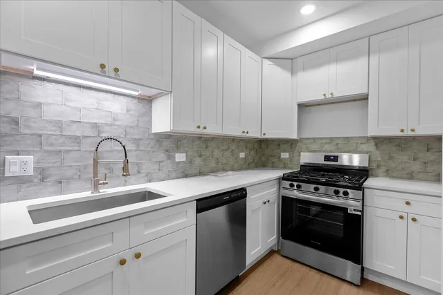 a kitchen with white cabinets stainless steel appliances and sink