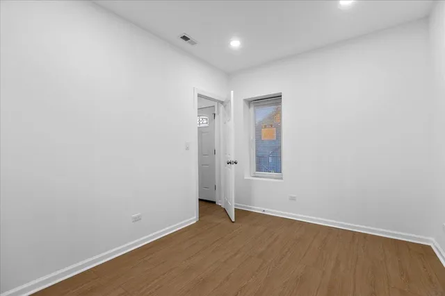 an empty room with wooden floor and window