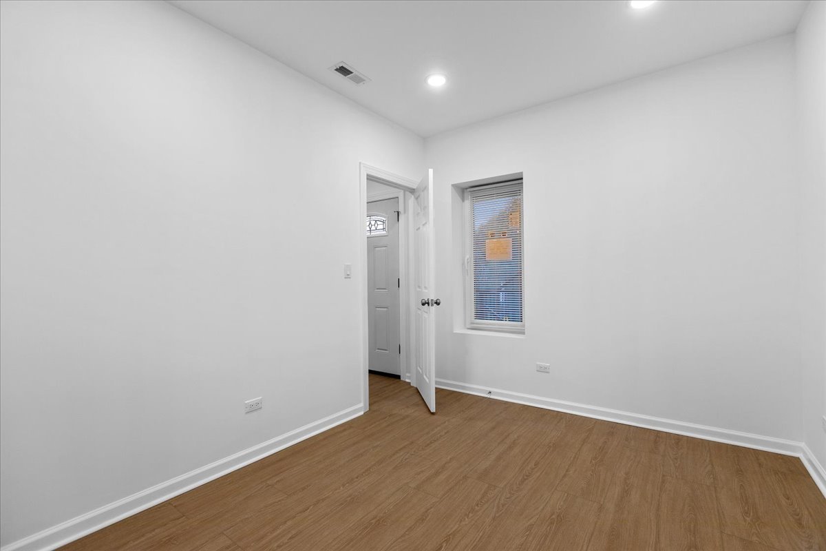 1313 West Chicago Avenue, Unit 3F Chicago, IL 60642 - Photo 8 of 16 an empty room with wooden floor and window