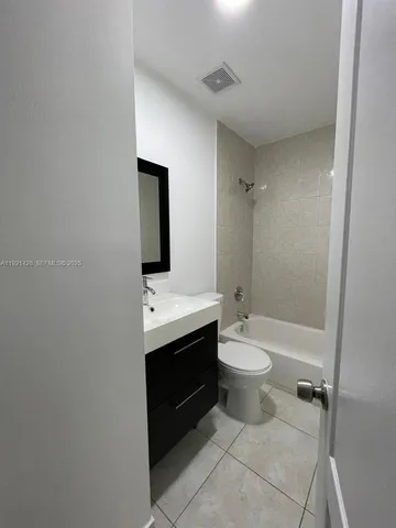a bathroom with a double vanity sink toilet mirror and shower