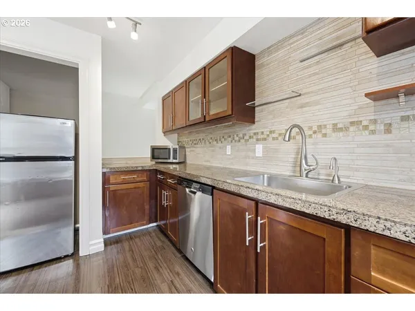 a kitchen with granite countertop stainless steel appliances a sink and cabinets