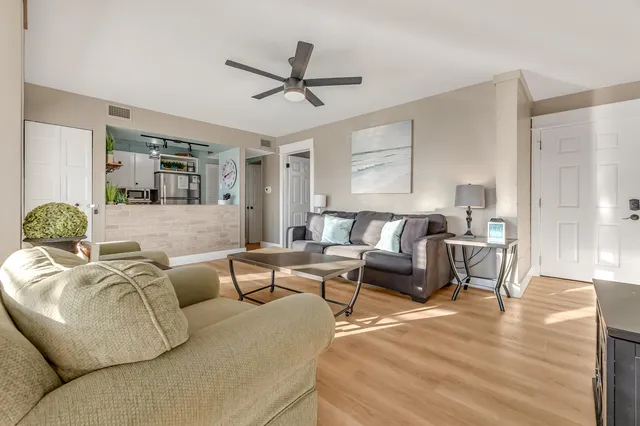 a living room with furniture and a wooden floor