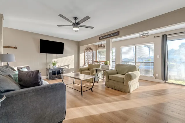 a living room with furniture a flat screen tv and a large window