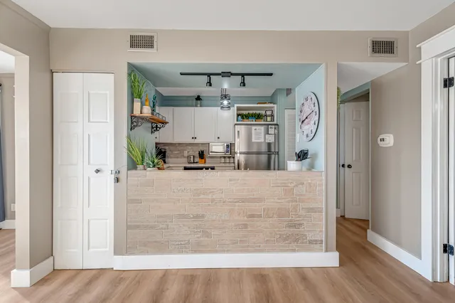 a view of kitchen with refrigerator and wooden floor
