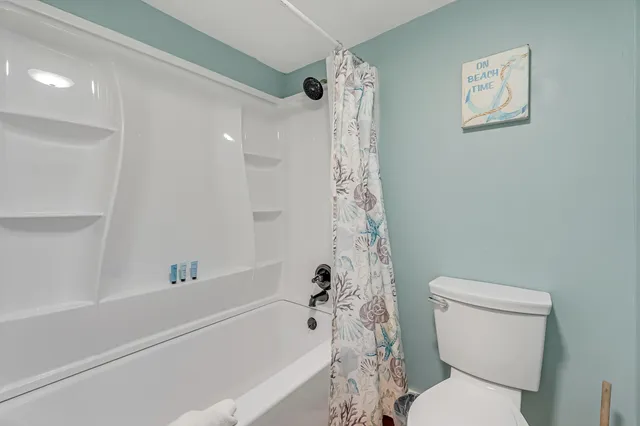 a white toilet sitting next to a bath tub shower