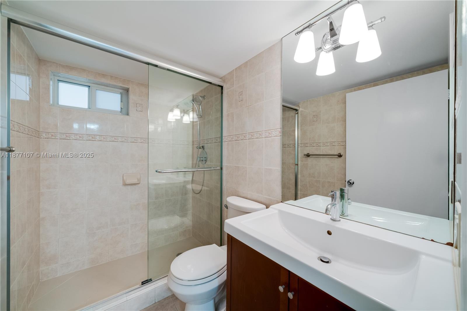 1665 Bay Road, Unit 521 Miami Beach, FL 33139 - Photo 11 of 25 a bathroom with a sink toilet a mirror and shower