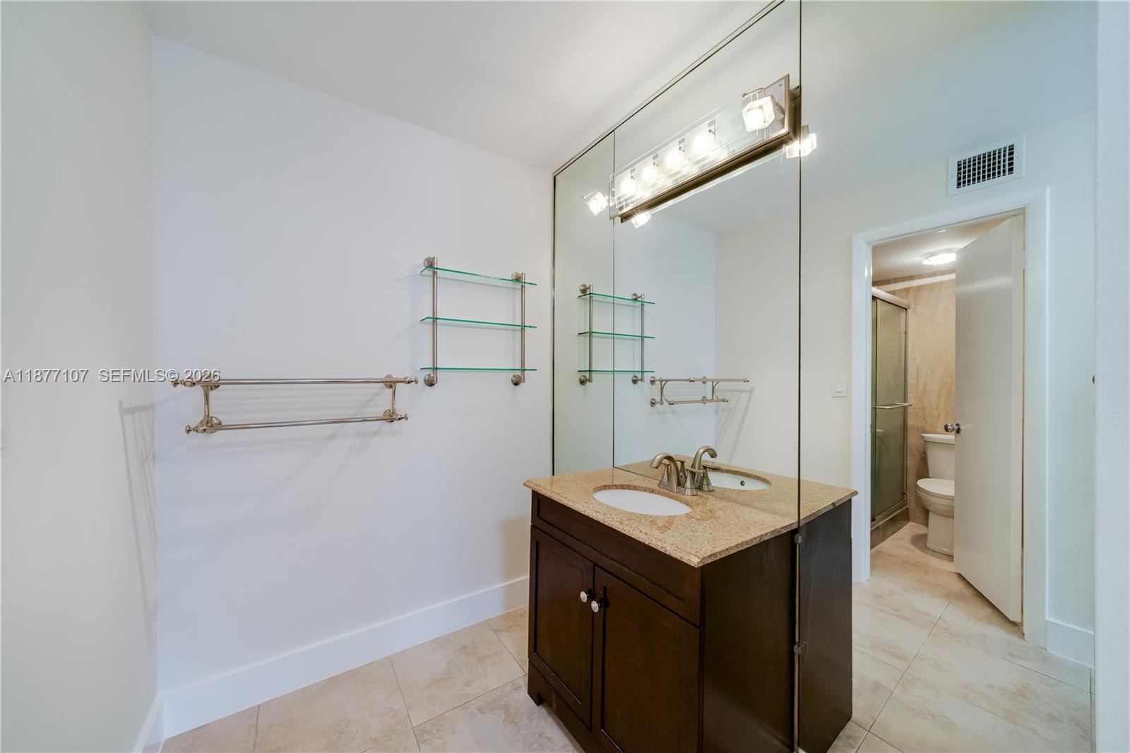 1665 Bay Road, Unit 521 Miami Beach, FL 33139 - Photo 16 of 25 a bathroom with a sink vanity and a mirror