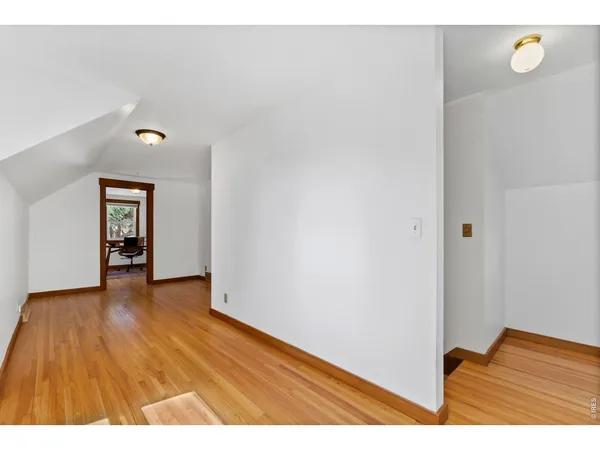 a view of an empty room with wooden floor