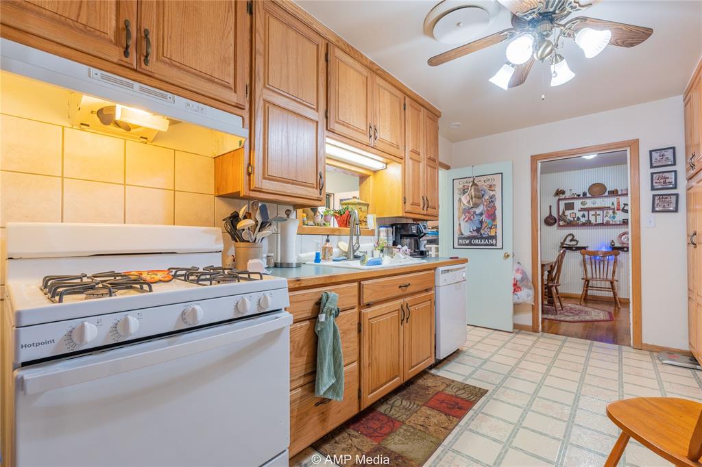 704 East Burnside Street Rotan, TX 79546 - Photo 11 of 31 a kitchen with stainless steel appliances granite countertop a stove a sink and a refrigerator