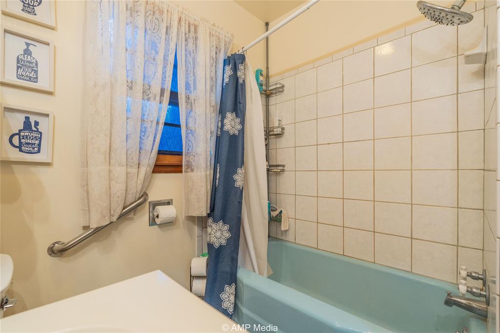 704 East Burnside Street Rotan, TX 79546 - Photo 16 of 31 a bathroom with a tub and a shower
