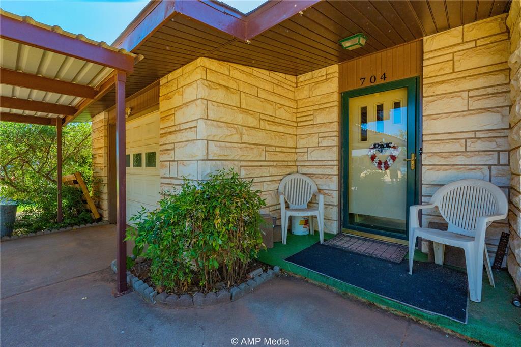 704 East Burnside Street Rotan, TX 79546 - Photo 5 of 31 a view of a porch with chairs and potted plants