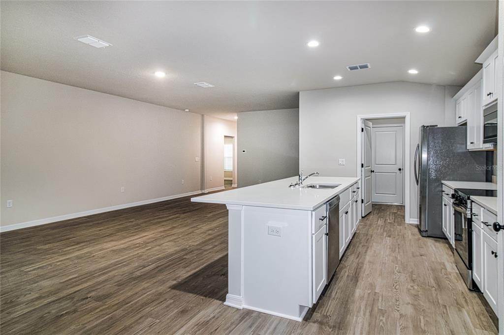 46 Ash Road Ocala, FL 34472 - Photo 8 of 20 a kitchen that has a sink wooden floor and stainless steel appliances